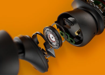 Фотографія крупним планом, на якій зображено внутрішні компоненти  справжніх бездротових навушників