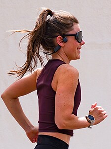 Женщина, занимающаяся бегом в наушниках с костной проводимостью