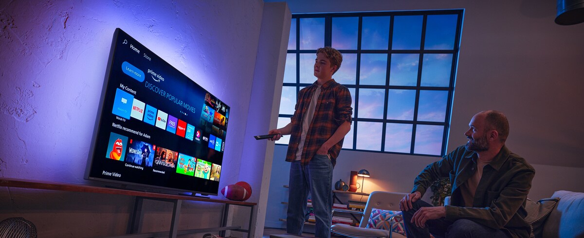 Людина, що вибирає додаток на телевізорі Philips Smart TV